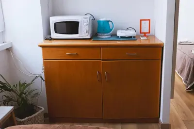 a microwave sitting on top of a wooden cabinet at Charming 3-Guest Apt in San Giovanni Landmark in Rome