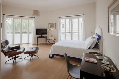 a bedroom with a bed and chairs and a television at Tiber Island View - Trastevere, Campo de' Fiori in Rome