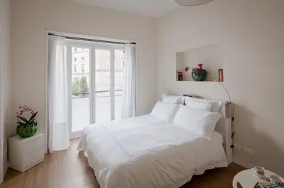 a white bedroom with a white bed and a window at Tiber Island View - Trastevere, Campo de' Fiori in Rome