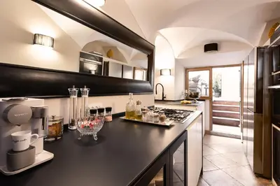 a kitchen with a black counter top and a stove at Idyllia - Luxury home with terrace in Rome