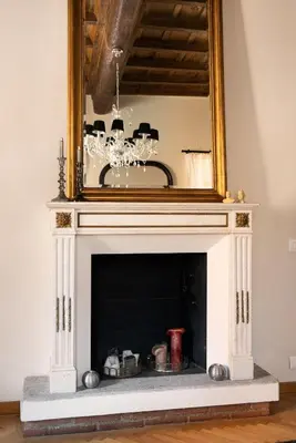 a fireplace with a mirror on top of it at Idyllia - Luxury home with terrace in Rome