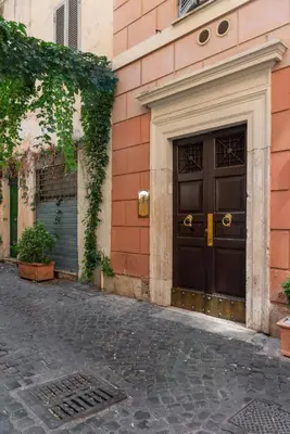 a building with a brown door on a street at Appartamento vicolo Savelli in Rome