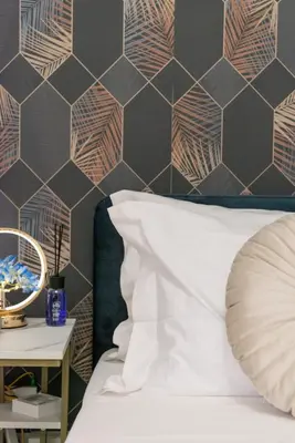 a bed with a white pillow and a hexagonal wall at Appartamento vicolo Savelli in Rome