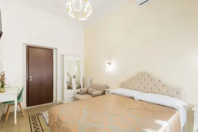 a white bedroom with a large bed and a chair at Just Chilling Home in Rome