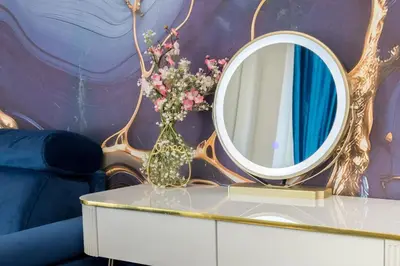 a mirror on top of a table with a vase with flowers at Just Chilling Home in Rome