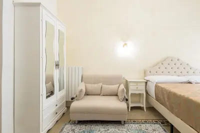 a white bedroom with a chair and a bed at Just Chilling Home in Rome