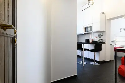 a kitchen with white cabinets and a table in a room at Casetta di quartiere Roma in Rome