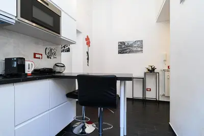 a kitchen with a counter and a black chair at Casetta di quartiere Roma in Rome