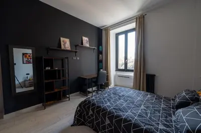 a bedroom with a bed and a desk and a window at Casa Mercanti in Rome