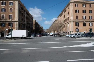an empty city street with cars parked on the street at Casa Mercanti in Rome