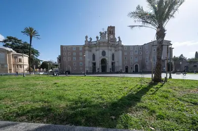 a building with a palm tree in front of it at Casa Mercanti in Rome