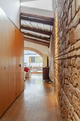 a living room with a brick wall and a hallway at The Loft Boutique Apartment Vatican Museum in Rome