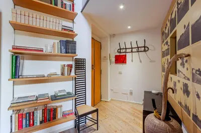 a living room with bookshelves and a chair at The Loft Boutique Apartment Vatican Museum in Rome