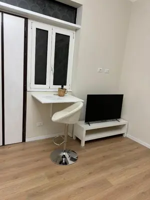 a living room with a chair and a television at JULIX - Roma Quadraro Apartment in Rome