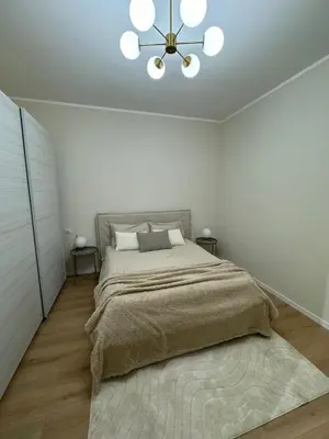a bedroom with a large bed and a chandelier at JULIX - Roma Quadraro Apartment in Rome