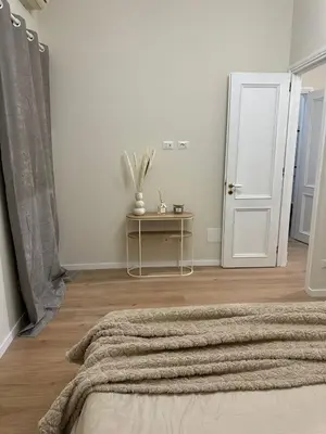 a white room with a bed and a table and a door at JULIX - Roma Quadraro Apartment in Rome
