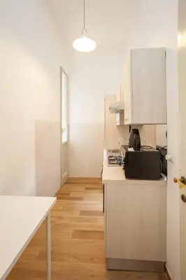 a kitchen with white appliances and wooden floors at Large Apartment near Coliseum in Rome