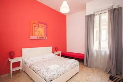 a red bedroom with a bed and a window at Large Apartment near Coliseum in Rome