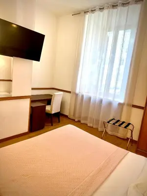 a bedroom with a desk and a large window at Green Hotel in Rome