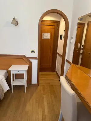a room with a bed and a table and a door at Green Hotel in Rome