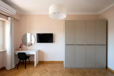 a bedroom with a white bed and a painting on the wall at Apartment near Vatican & Foro Italico - Rome in Rome