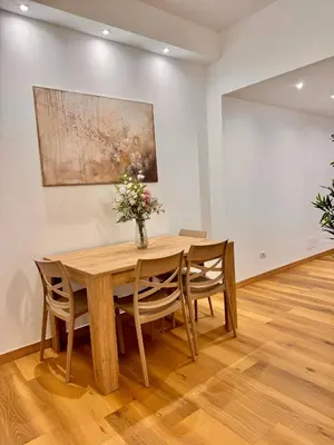 a dining room table with chairs and a vase of flowers at Lolus House in Rome