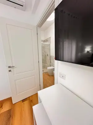 a white kitchen with a door and a microwave at Lolus House in Rome
