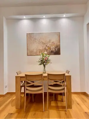 a dining room table with two chairs and a vase of flowers at Lolus House in Rome