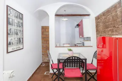 a kitchen with a table and chairs and a red refrigerator at Il Piccolo Arco in Rome