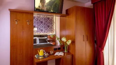 a room with a cabinet with a mirror and a red curtain at IN Roma Vale&Hillary colosseo b&b in Rome
