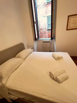 a bed with two towels on it with a window at Residenza Coronari in Rome