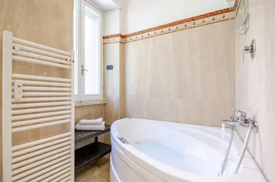 a bathroom with a white tub and a window at Hot Tub - Private Parking - park in Rome