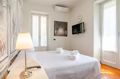 a bedroom with a large white bed with towels on it at Hot Tub - Private Parking - park in Rome