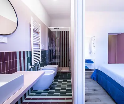 a bathroom with a tub and a toilet and a bed at La Garbatella dei Cesaroni in Rome