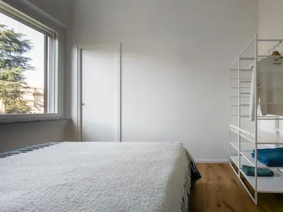 a bedroom with a white bed and a window at La Garbatella dei Cesaroni in Rome