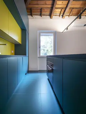 a large kitchen with blue cabinets and a window at La Garbatella dei Cesaroni in Rome