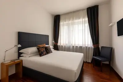 a bedroom with a large white bed and a chair at Casa Sacchi by Hili in Rome