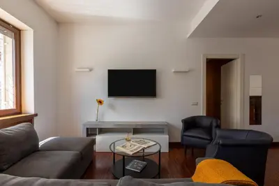 a living room with a couch and a tv on the wall at Casa Sacchi by Hili in Rome
