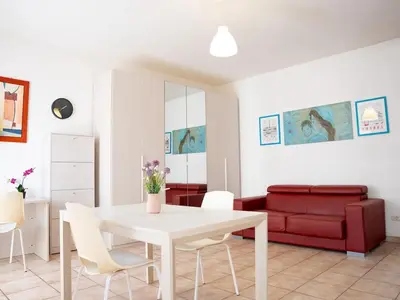 a living room with a white table and a red couch at Furio Camillo, Roma Centro in Rome