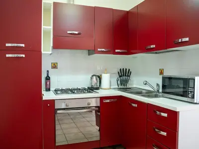 a kitchen with red cabinets and a stove top oven at Furio Camillo, Roma Centro in Rome