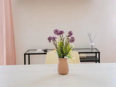 a vase with purple flowers sitting on a table at Furio Camillo, Roma Centro in Rome