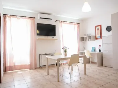 a living room with a table and chairs and a tv at Furio Camillo, Roma Centro in Rome