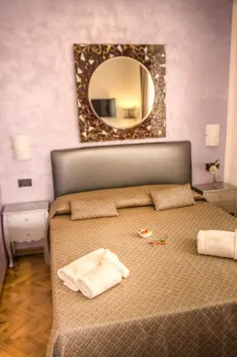 a bedroom with a bed with a mirror on the wall at Relais Calamatta in Rome