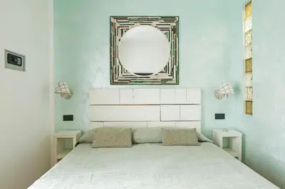 a bedroom with a bed with a mirror on the wall at Relais Calamatta in Rome