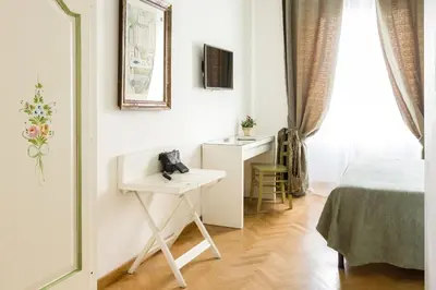 a room with a table and a bed and a desk at Relais Calamatta in Rome