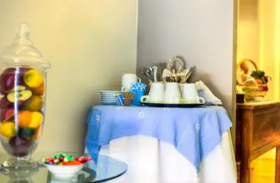 a table with a blue table cloth and a bowl of fruit at Relais Calamatta in Rome