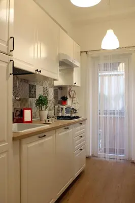 a white kitchen with white cabinets and a window at Holiday Home Roma in Rome