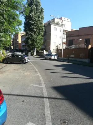 an empty street with cars parked on the road at Holiday Home Roma in Rome
