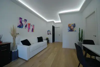 a bedroom with a bed and two chairs and a television at Suites Conca D'Oro, Roma in Rome
