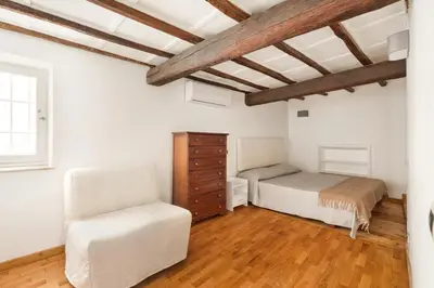 a bedroom with two beds and a chair at Navona Square in Rome